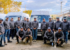 The E. Costa Plumbing team — twelve licensed plumbers in front of company vans in West Palm Beach, FL